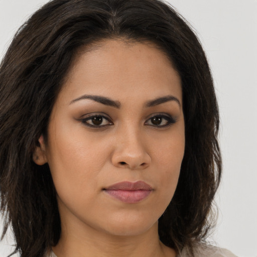 Joyful latino young-adult female with long  brown hair and brown eyes