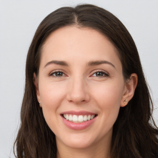 Joyful white young-adult female with long  brown hair and grey eyes