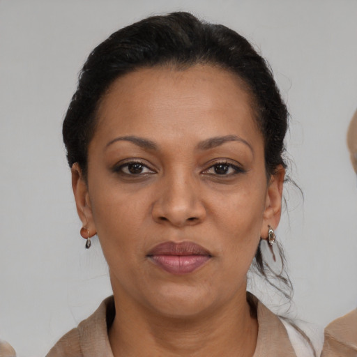 Joyful black adult female with medium  brown hair and brown eyes