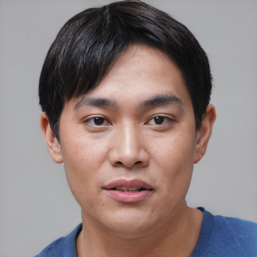 Joyful asian young-adult male with short  black hair and brown eyes
