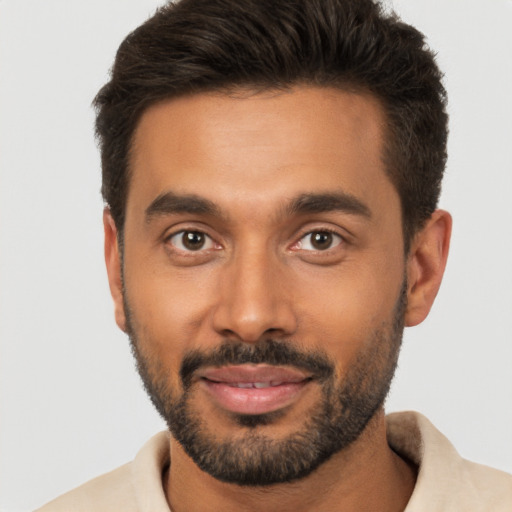 Joyful black young-adult male with short  brown hair and brown eyes