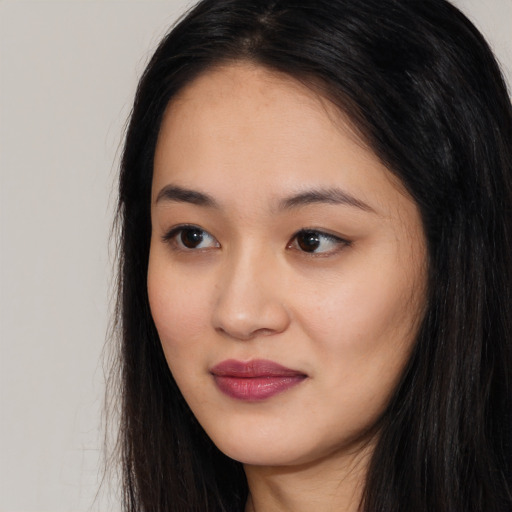Joyful asian young-adult female with long  black hair and brown eyes