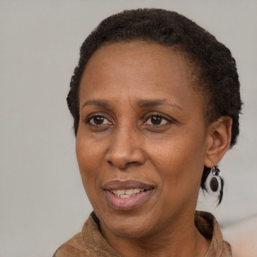 Joyful black adult female with short  brown hair and brown eyes