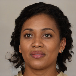 Joyful black adult female with medium  brown hair and brown eyes