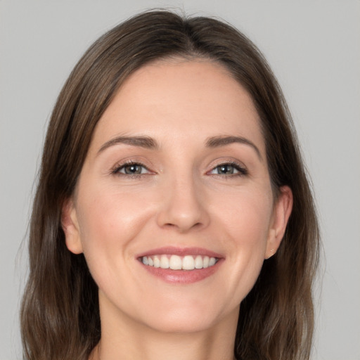 Joyful white young-adult female with long  brown hair and grey eyes