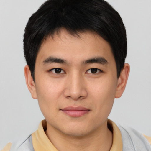 Joyful asian young-adult male with short  black hair and brown eyes