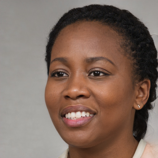 Joyful black young-adult female with medium  brown hair and brown eyes