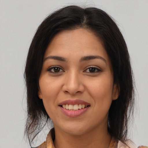 Joyful latino young-adult female with medium  brown hair and brown eyes
