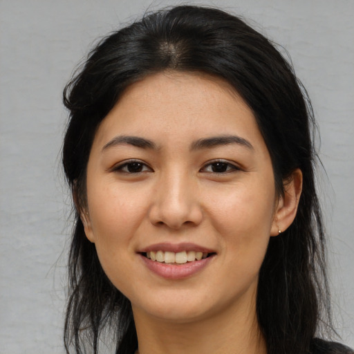 Joyful asian young-adult female with long  brown hair and brown eyes