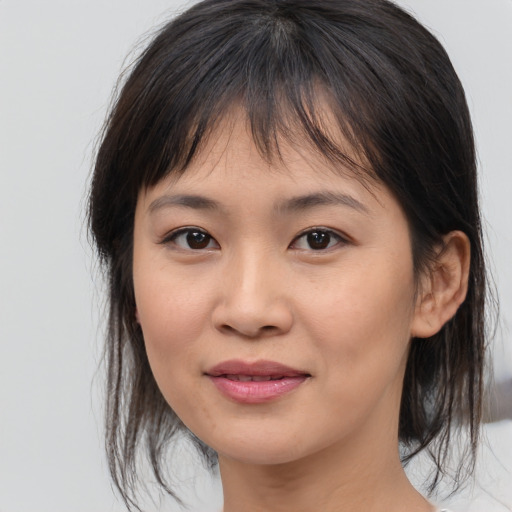 Joyful asian young-adult female with medium  brown hair and brown eyes
