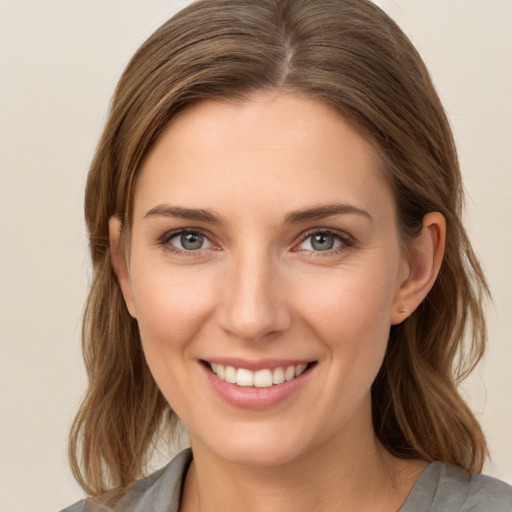 Joyful white young-adult female with medium  brown hair and grey eyes