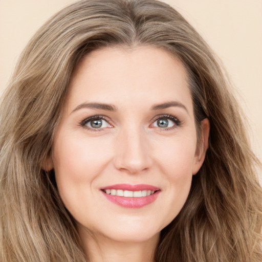 Joyful white young-adult female with long  brown hair and green eyes