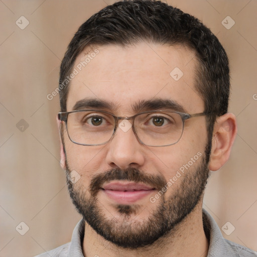 Joyful white adult male with short  black hair and brown eyes