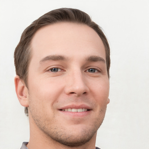 Joyful white young-adult male with short  brown hair and grey eyes