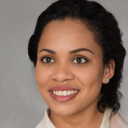 Joyful black young-adult female with medium  black hair and brown eyes