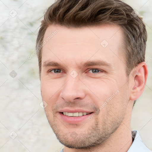 Joyful white young-adult male with short  brown hair and grey eyes