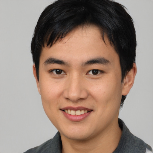 Joyful asian young-adult male with medium  black hair and brown eyes