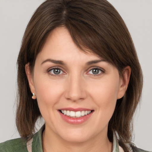 Joyful white young-adult female with medium  brown hair and grey eyes