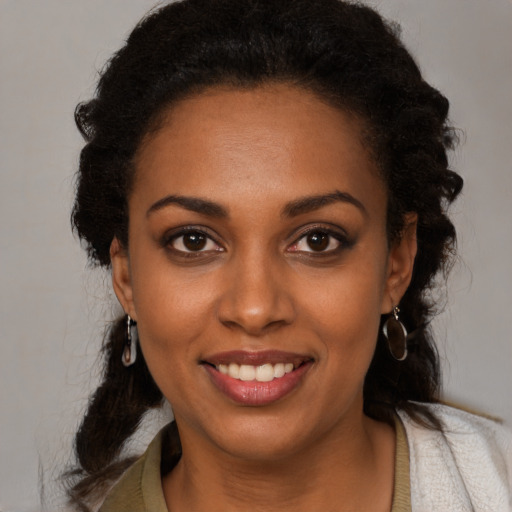Joyful black young-adult female with long  black hair and brown eyes
