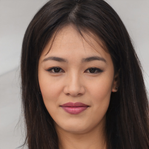 Joyful asian young-adult female with long  brown hair and brown eyes
