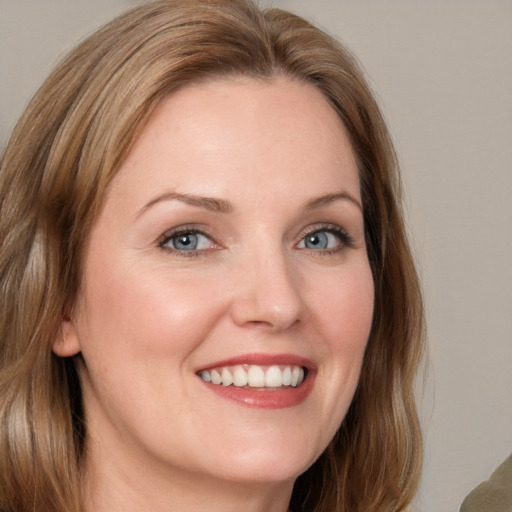 Joyful white young-adult female with medium  brown hair and blue eyes