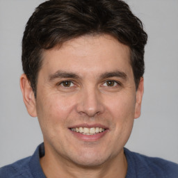 Joyful white adult male with short  brown hair and brown eyes