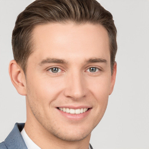 Joyful white young-adult male with short  brown hair and grey eyes