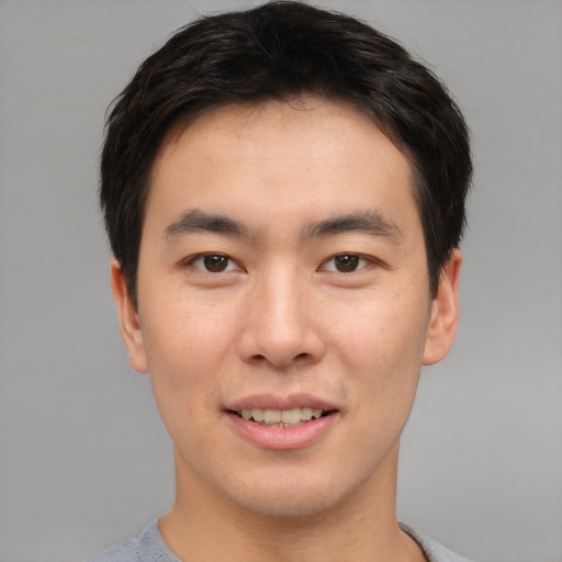 Joyful asian young-adult male with short  brown hair and brown eyes