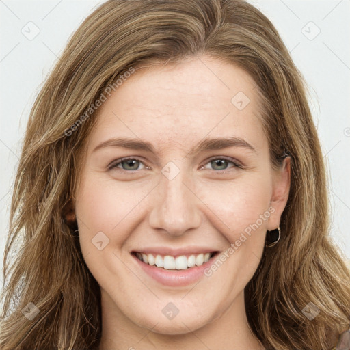 Joyful white young-adult female with long  brown hair and green eyes