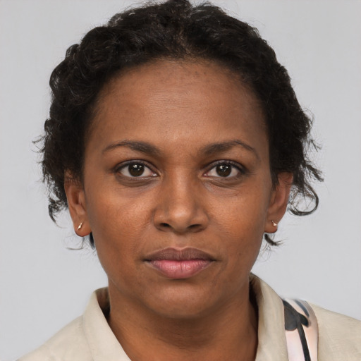 Joyful black adult female with short  brown hair and brown eyes