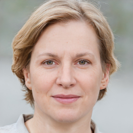 Joyful white adult female with medium  brown hair and blue eyes