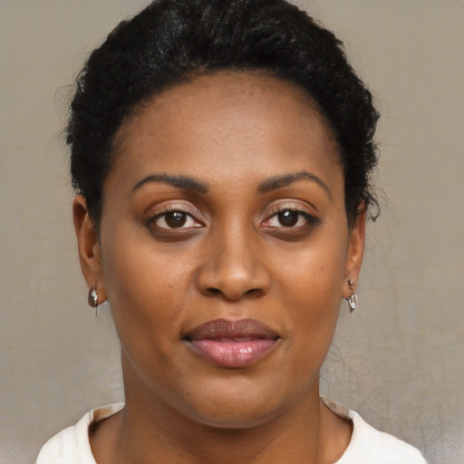 Joyful black young-adult female with short  brown hair and brown eyes