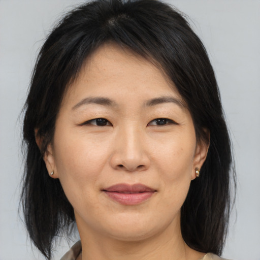 Joyful asian adult female with medium  brown hair and brown eyes