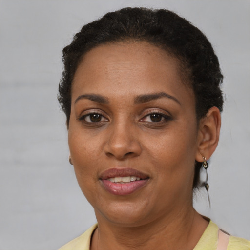 Joyful black adult female with short  brown hair and brown eyes
