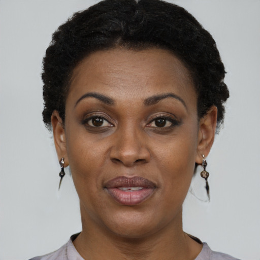 Joyful black adult female with short  black hair and brown eyes