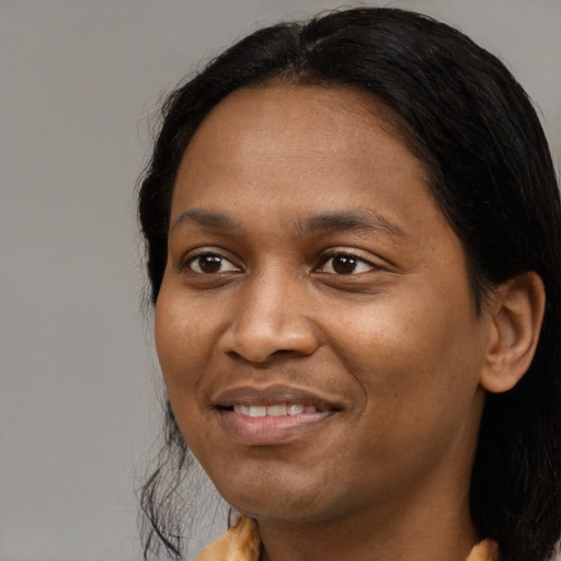 Joyful black adult female with long  black hair and brown eyes
