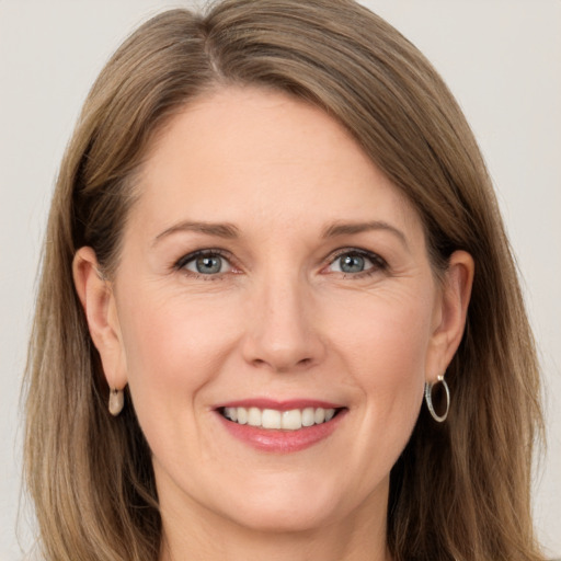 Joyful white adult female with long  brown hair and grey eyes