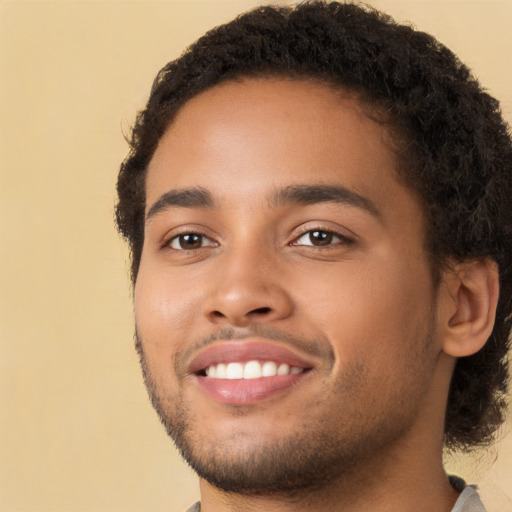 Joyful black young-adult male with short  brown hair and brown eyes