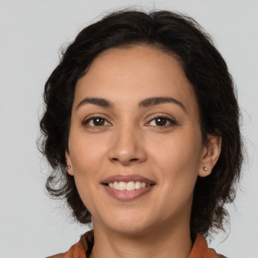 Joyful latino young-adult female with medium  brown hair and brown eyes