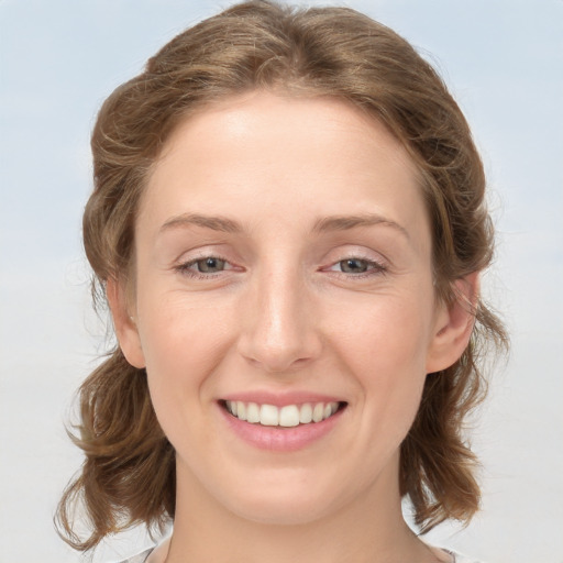 Joyful white young-adult female with medium  brown hair and blue eyes