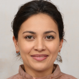 Joyful latino young-adult female with medium  brown hair and brown eyes