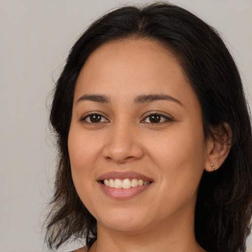 Joyful latino young-adult female with medium  brown hair and brown eyes