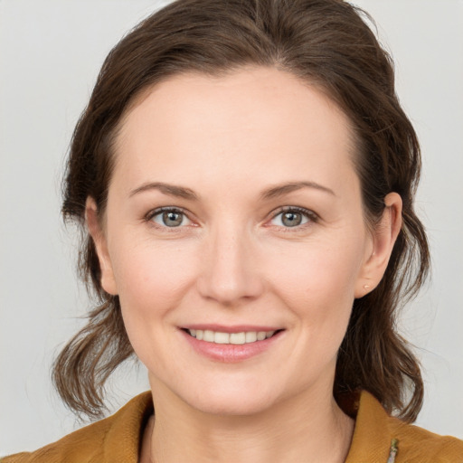 Joyful white young-adult female with medium  brown hair and grey eyes