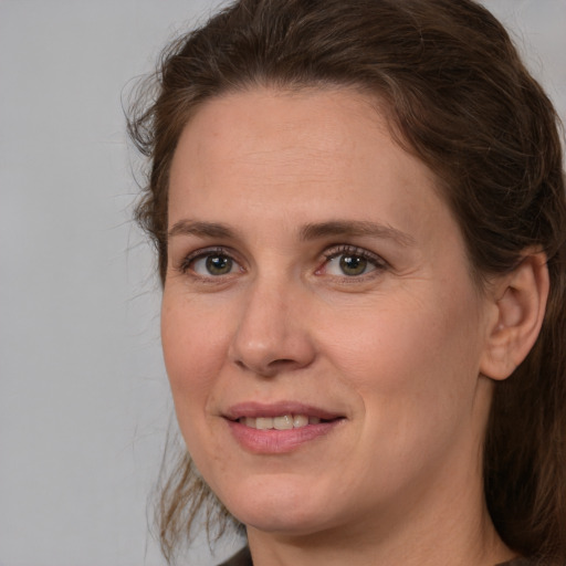 Joyful white adult female with medium  brown hair and brown eyes