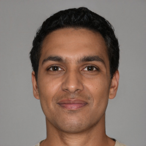 Joyful latino young-adult male with short  black hair and brown eyes