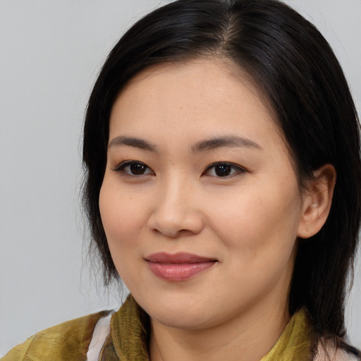 Joyful asian young-adult female with medium  black hair and brown eyes