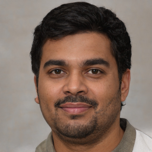 Joyful latino young-adult male with short  black hair and brown eyes
