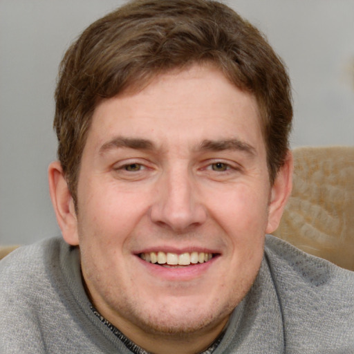 Joyful white adult male with short  brown hair and blue eyes