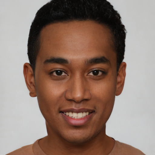 Joyful black young-adult male with short  black hair and brown eyes