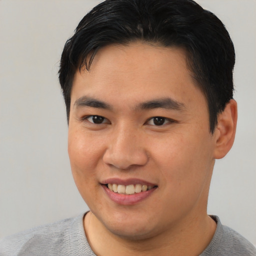 Joyful asian young-adult male with short  brown hair and brown eyes